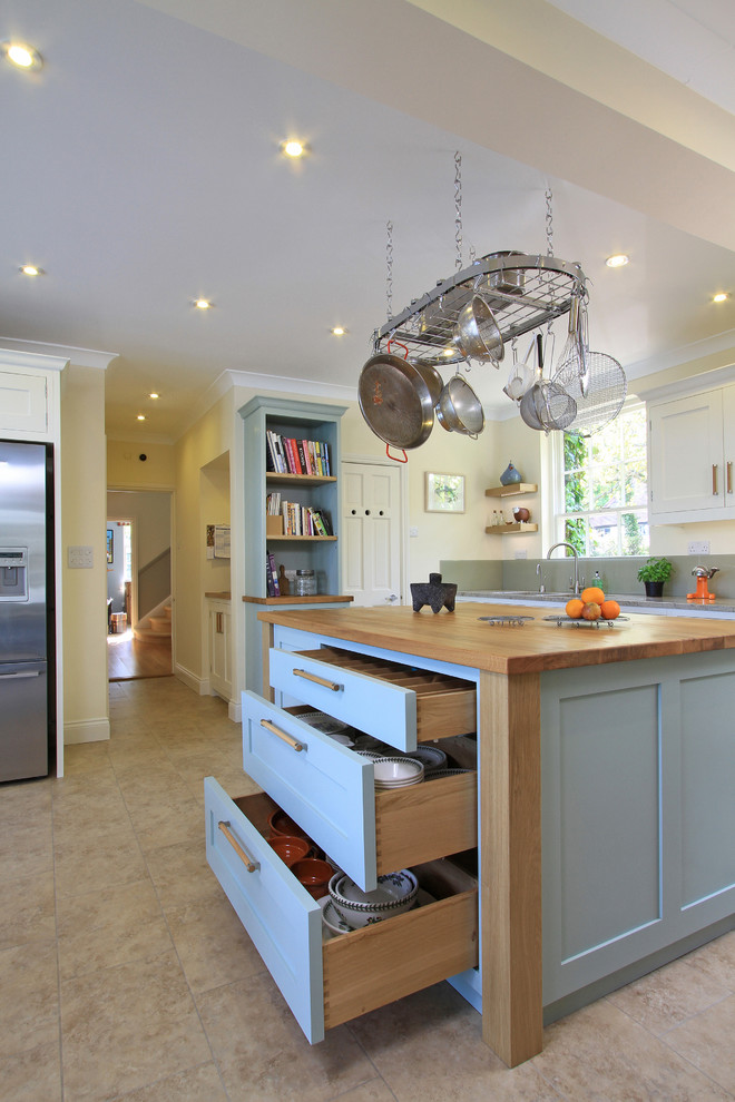Example of an ornate kitchen design in Hampshire with shaker cabinets, stainless steel appliances, wood countertops and blue cabinets