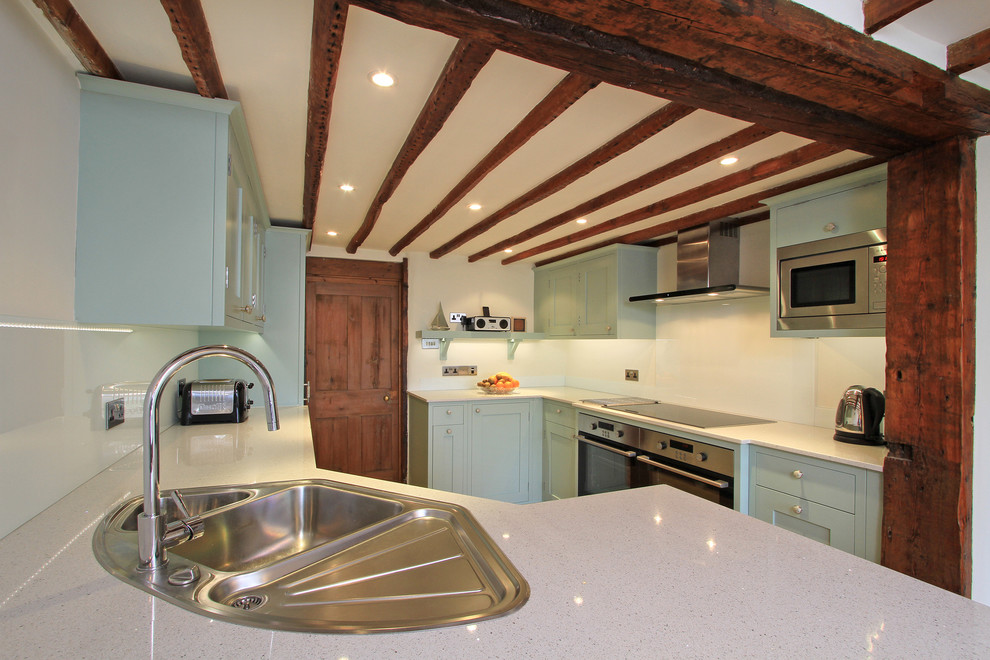 Inspiration for a classic kitchen in Hampshire with a built-in sink, blue cabinets, engineered stone countertops and glass sheet splashback.