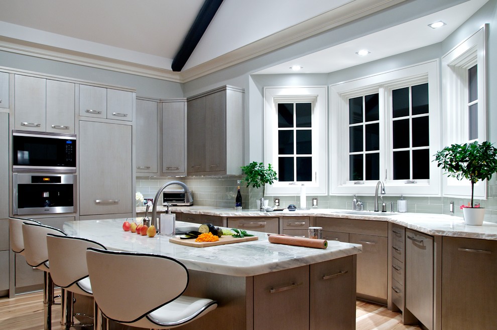 Источник вдохновения для домашнего уюта: кухня в стиле неоклассика (современная классика) с техникой из нержавеющей стали, плоскими фасадами, серыми фасадами, зеленым фартуком и эркером