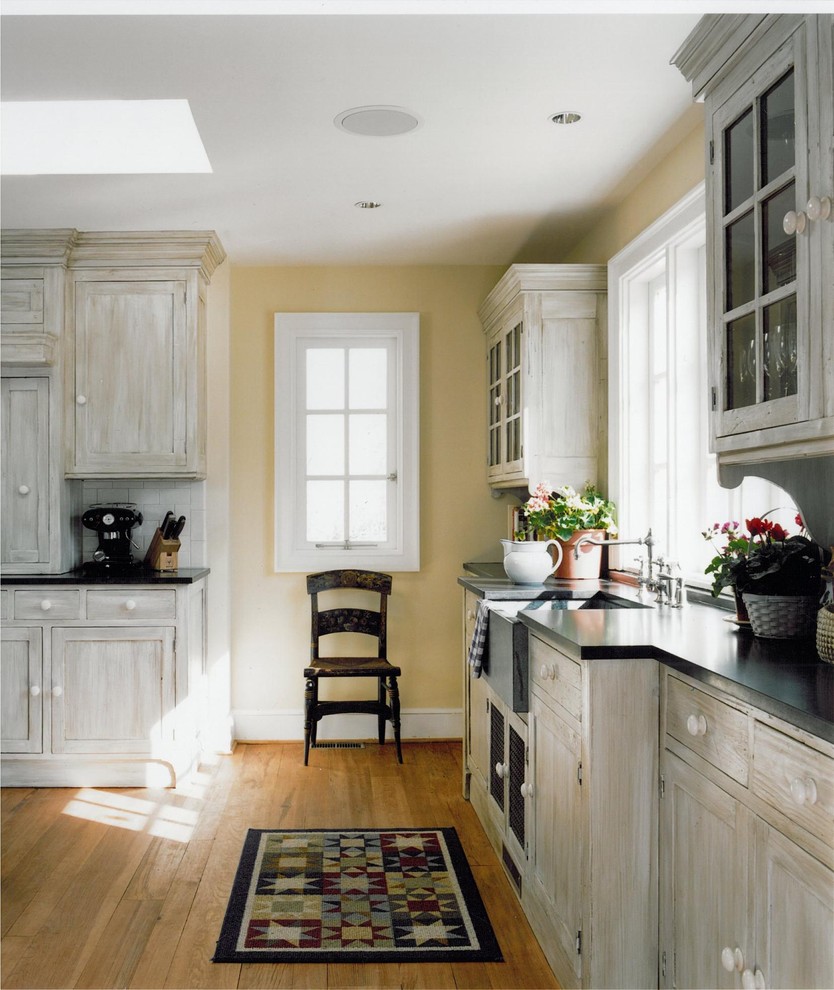 Diseño de cocina campestre de obra con armarios tipo vitrina, fregadero sobremueble y puertas de armario blancas