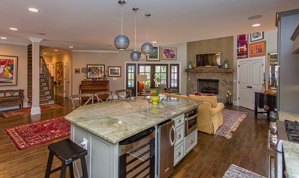Foto på ett mellanstort eklektiskt kök och matrum, med rostfria vitvaror, mörkt trägolv, en köksö, luckor med profilerade fronter, skåp i mellenmörkt trä, granitbänkskiva och brunt golv