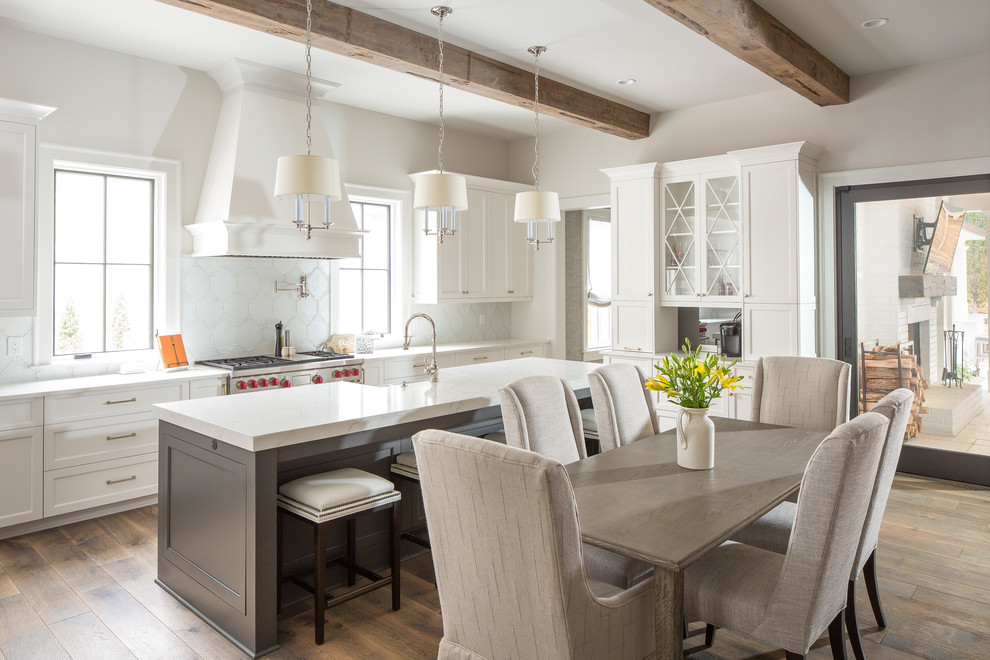 Eat-in kitchen - traditional medium tone wood floor eat-in kitchen idea in Atlanta with a farmhouse sink, white cabinets, quartzite countertops, white backsplash, ceramic backsplash, stainless steel appliances, an island, white countertops and shaker cabinets