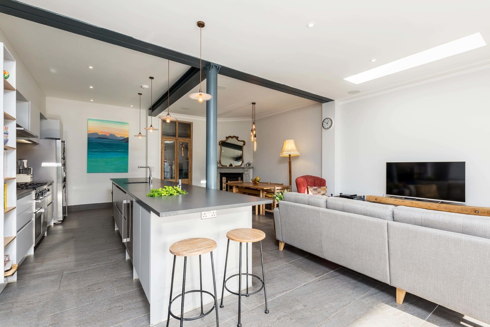 Contemporary kitchen in Hampshire with flat-panel cabinets, grey splashback, stainless steel appliances, an island, grey floors and grey worktops.