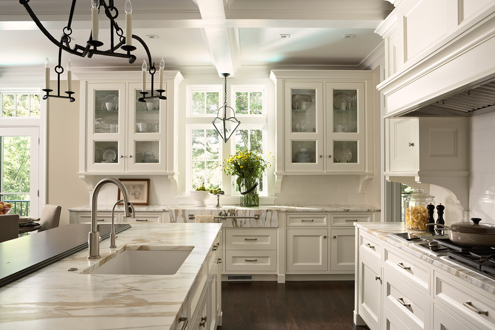 Foto på ett stort vintage kök, med en enkel diskho, luckor med glaspanel, vita skåp, marmorbänkskiva, vitt stänkskydd, stänkskydd i keramik, integrerade vitvaror, en köksö och mörkt trägolv