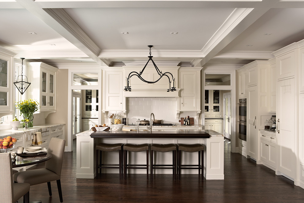 Inspiration for a large transitional u-shaped dark wood floor open concept kitchen remodel in Minneapolis with a single-bowl sink, flat-panel cabinets, white cabinets, marble countertops, white backsplash, ceramic backsplash, paneled appliances and an island