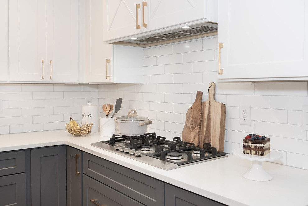 Foto på ett stort lantligt vit kök, med en undermonterad diskho, skåp i shakerstil, grå skåp, bänkskiva i kvarts, vitt stänkskydd, stänkskydd i keramik, rostfria vitvaror, mellanmörkt trägolv och en köksö