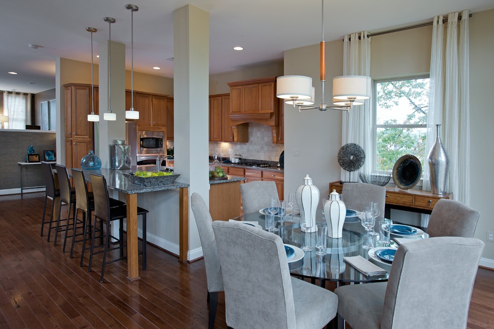 На фото: угловая кухня в современном стиле с обеденным столом, фасадами с выступающей филенкой и фасадами цвета дерева среднего тона с