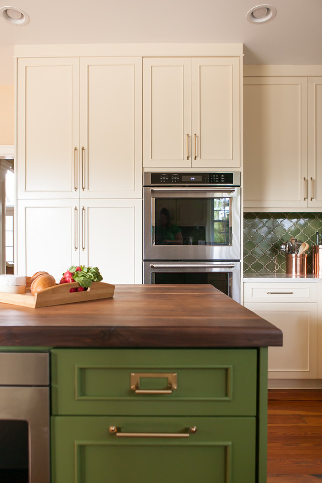 Exempel på ett klassiskt vit vitt kök och matrum, med en nedsänkt diskho, beige skåp, bänkskiva i kvarts, grönt stänkskydd, stänkskydd i keramik, rostfria vitvaror, mellanmörkt trägolv och en köksö