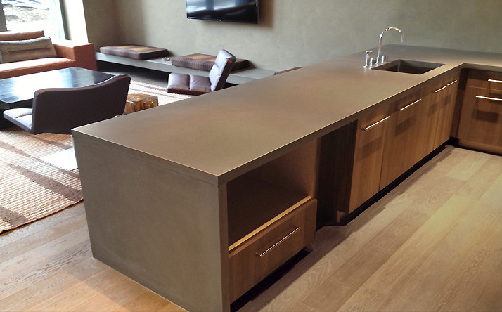 This is an example of a large contemporary l-shaped kitchen/diner in New York with a built-in sink, concrete worktops, light hardwood flooring and an island.
