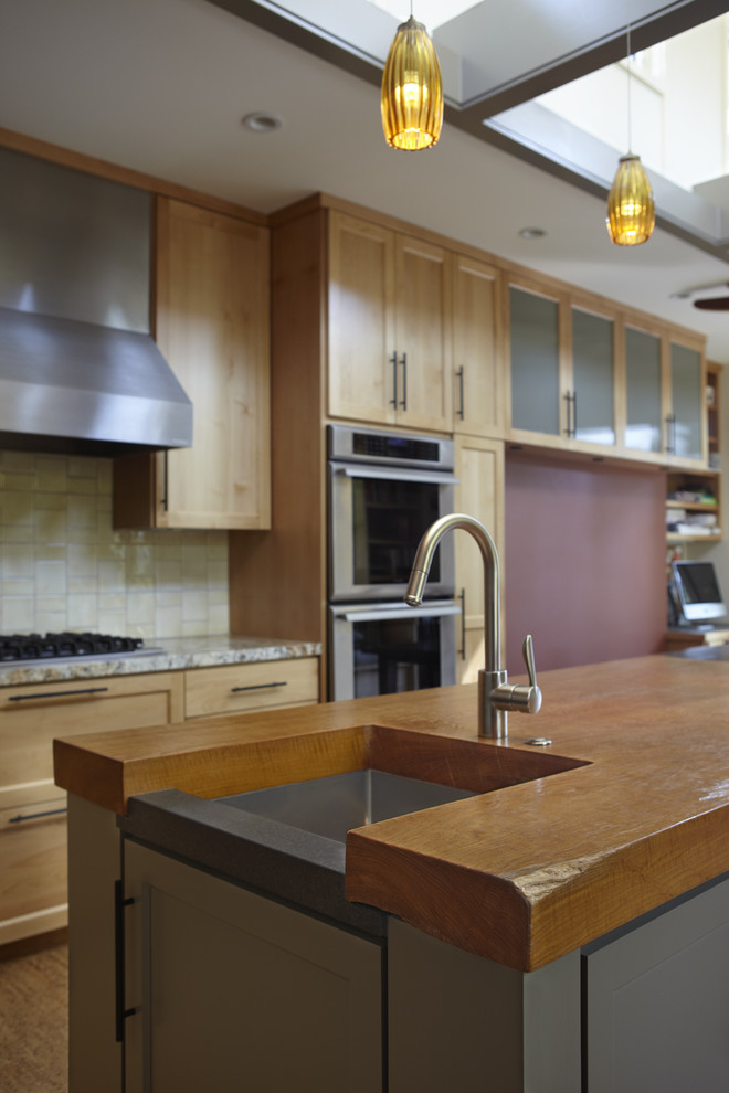 Mid-sized minimalist l-shaped medium tone wood floor eat-in kitchen photo in San Francisco with an undermount sink, shaker cabinets, medium tone wood cabinets, granite countertops, beige backsplash, cement tile backsplash, stainless steel appliances and an island