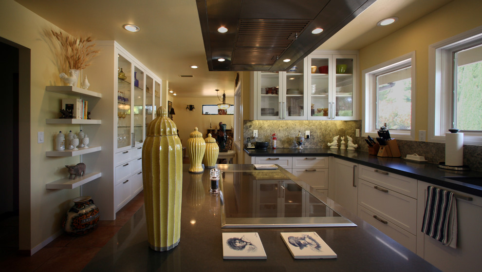 Example of a mid-sized transitional u-shaped medium tone wood floor enclosed kitchen design in Phoenix with an undermount sink, glass-front cabinets, white cabinets, gray backsplash, paneled appliances, an island and quartz countertops