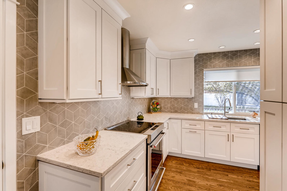 Eat-in kitchen - mid-sized transitional u-shaped medium tone wood floor and brown floor eat-in kitchen idea in Other with an undermount sink, shaker cabinets, white cabinets, quartz countertops, gray backsplash, porcelain backsplash, stainless steel appliances and gray countertops