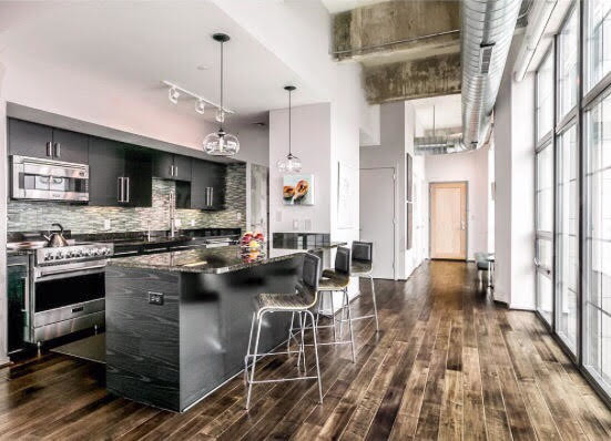 Eat-in kitchen - large industrial u-shaped dark wood floor and brown floor eat-in kitchen idea in Baltimore with an undermount sink, flat-panel cabinets, black cabinets, granite countertops, green backsplash, glass tile backsplash, stainless steel appliances and an island