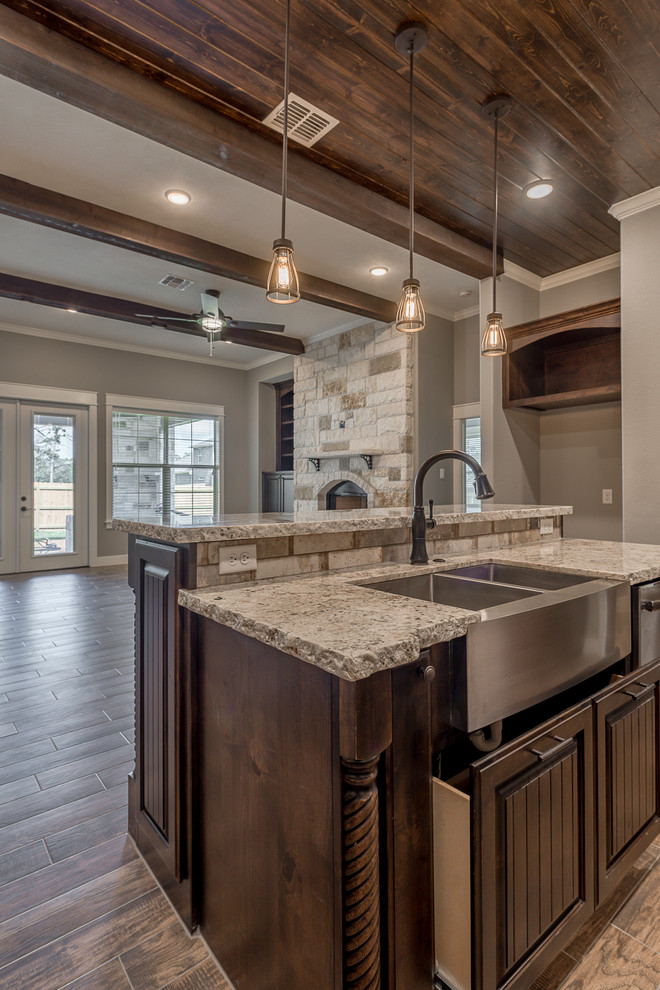 Inspiration for a mid-sized industrial u-shaped ceramic tile and brown floor kitchen pantry remodel in Other with a farmhouse sink, raised-panel cabinets, dark wood cabinets, granite countertops, multicolored backsplash, brick backsplash, stainless steel appliances and an island