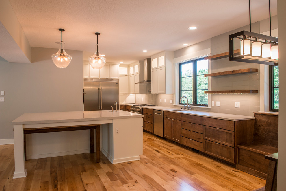 Inspiration for a large country medium tone wood floor eat-in kitchen remodel in Kansas City with an undermount sink, open cabinets, white cabinets, quartz countertops, gray backsplash, subway tile backsplash, stainless steel appliances and an island
