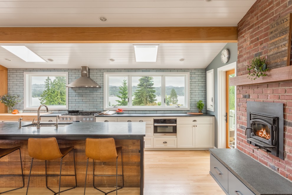 Rustikale Küche mit weißen Schränken, Küchenrückwand in Blau, Rückwand aus Backstein, braunem Holzboden und Kücheninsel in San Francisco