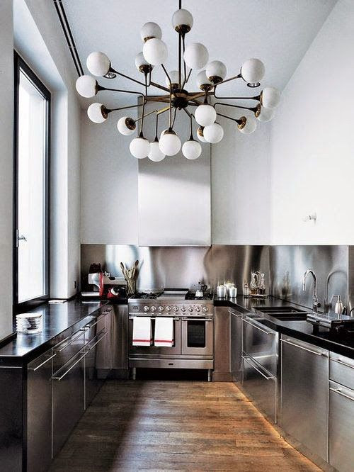 Inspiration for a mid-sized industrial u-shaped medium tone wood floor and brown floor eat-in kitchen remodel in Columbus with an undermount sink, flat-panel cabinets, stainless steel cabinets, granite countertops, metallic backsplash, stainless steel appliances and black countertops
