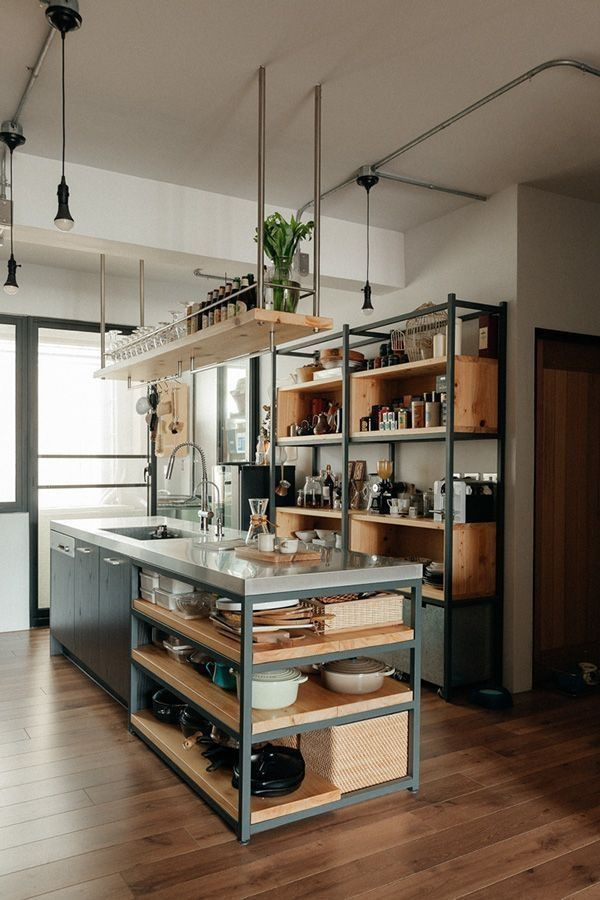 Idéer för ett litet industriellt grå linjärt kök och matrum, med en undermonterad diskho, öppna hyllor, svarta skåp, bänkskiva i betong, svarta vitvaror, mellanmörkt trägolv, en köksö och brunt golv