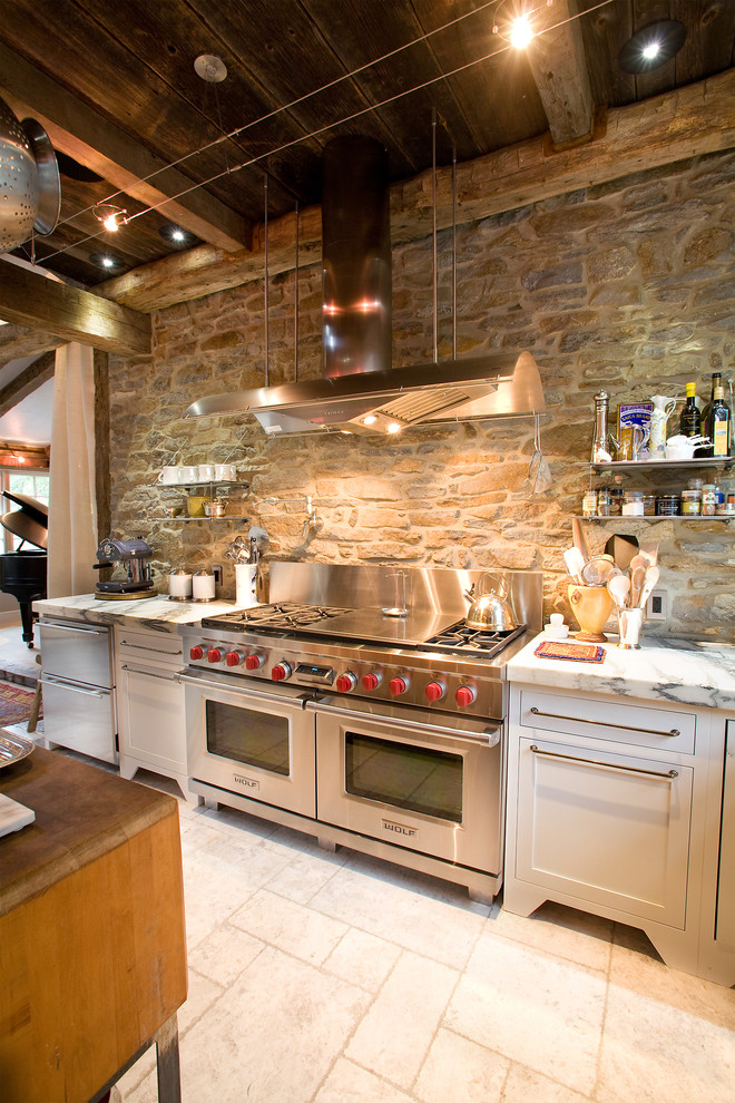 На фото: огромная угловая кухня-гостиная в стиле лофт с техникой из нержавеющей стали, мраморной столешницей, с полувстраиваемой мойкой (с передним бортиком), фасадами в стиле шейкер, белыми фасадами и островом