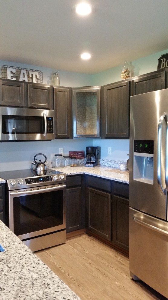 Inspiration for a small industrial u-shaped vinyl floor eat-in kitchen remodel in Milwaukee with an undermount sink, shaker cabinets, black cabinets, granite countertops, white backsplash, subway tile backsplash, stainless steel appliances and a peninsula