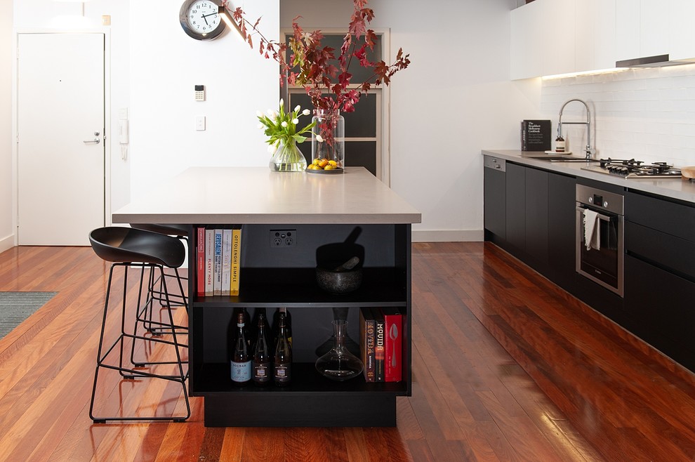 Mid-sized urban galley medium tone wood floor eat-in kitchen photo in Melbourne with an undermount sink, open cabinets, black cabinets, quartz countertops, white backsplash, subway tile backsplash, stainless steel appliances and an island