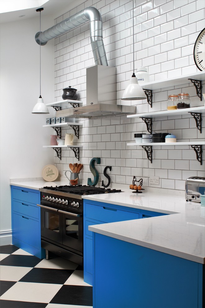 Inspiration for a small industrial l-shaped multicolored floor and linoleum floor enclosed kitchen remodel in Other with blue cabinets, white backsplash, subway tile backsplash, black appliances, a peninsula, a double-bowl sink, flat-panel cabinets and quartz countertops