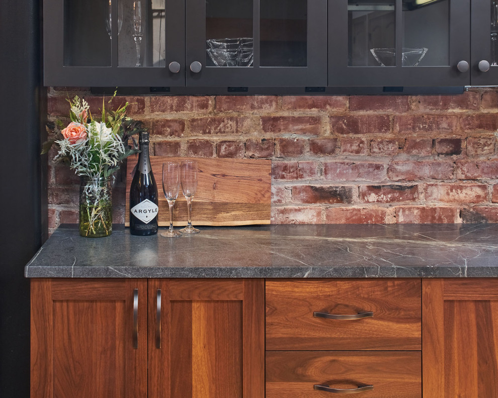 Exempel på ett mellanstort industriellt svart svart kök, med en rustik diskho, luckor med glaspanel, skåp i mörkt trä, bänkskiva i täljsten, flerfärgad stänkskydd, stänkskydd i keramik, rostfria vitvaror, mellanmörkt trägolv, en köksö och brunt golv