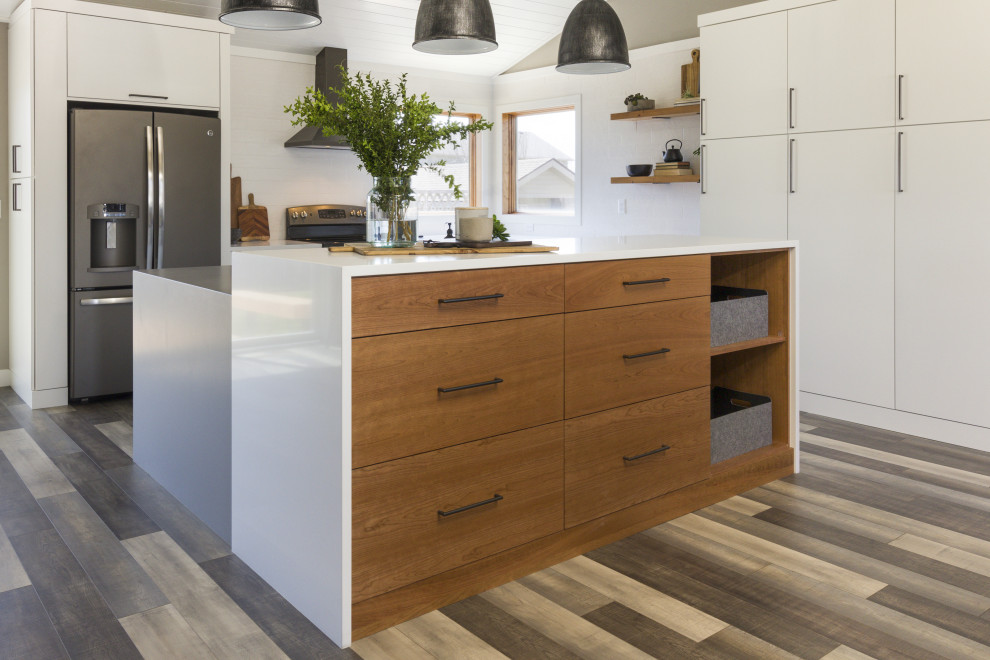 Example of a large urban l-shaped light wood floor and multicolored floor open concept kitchen design in Other with an undermount sink, white cabinets, quartz countertops, stainless steel appliances, an island and white countertops