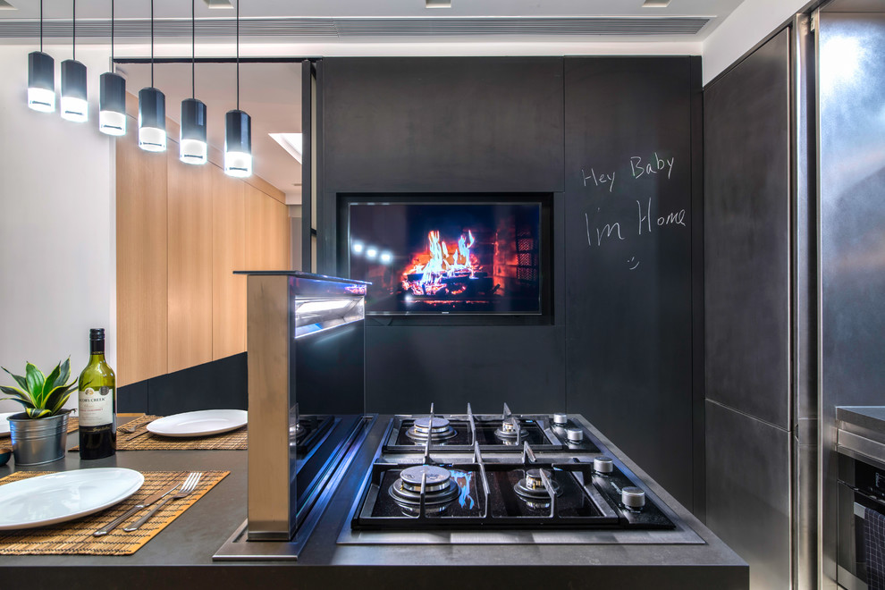 Inspiration för små industriella kök och matrum, med släta luckor, stänkskydd med metallisk yta, spegel som stänkskydd, betonggolv, en köksö, grått golv och skåp i rostfritt stål