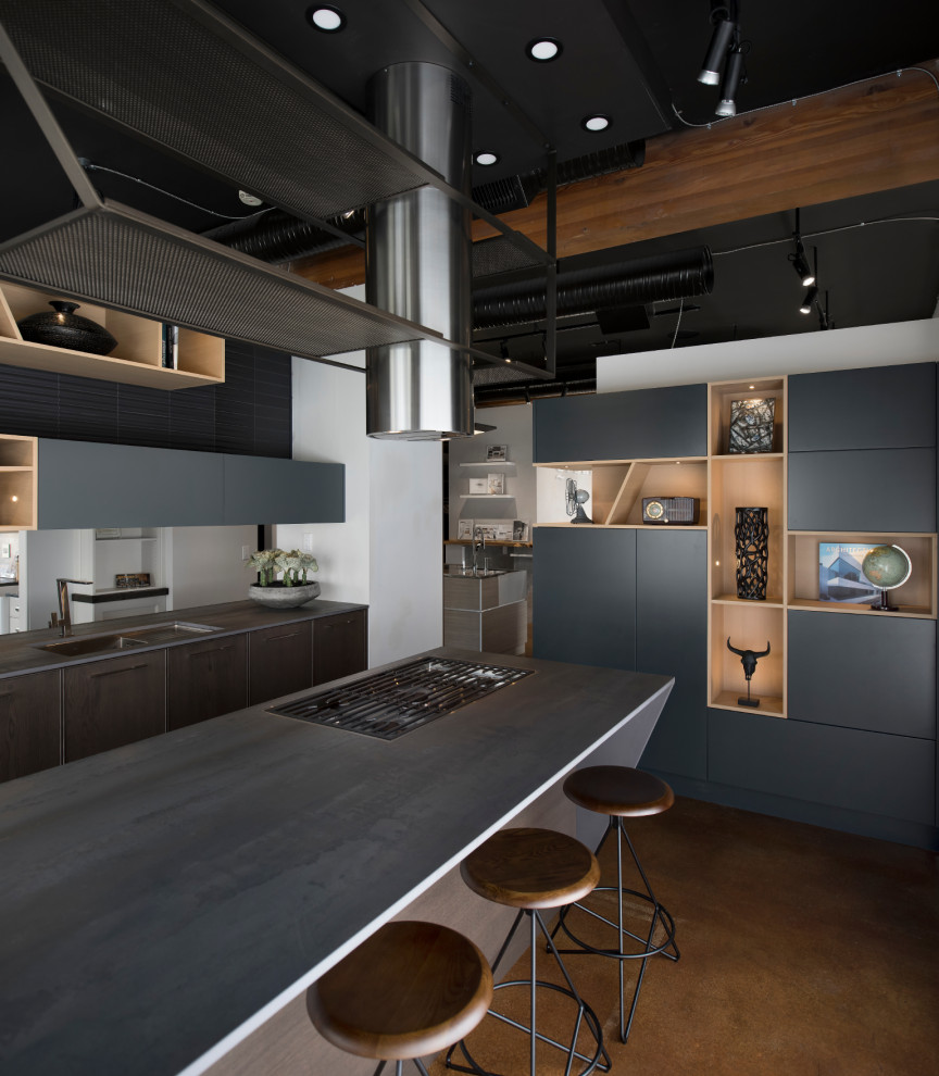 Example of a mid-sized minimalist l-shaped concrete floor and brown floor enclosed kitchen design in Vancouver with an undermount sink, flat-panel cabinets, light wood cabinets, solid surface countertops, black backsplash, ceramic backsplash, stainless steel appliances, an island and gray countertops