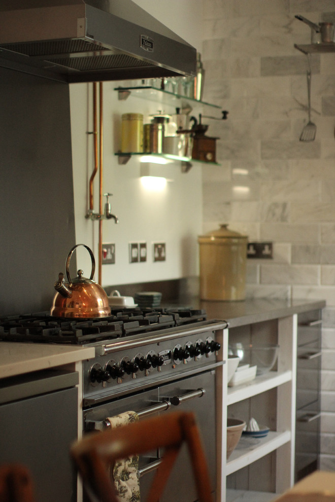 Bild på ett mellanstort industriellt linjärt kök och matrum, med en integrerad diskho, släta luckor, skåp i slitet trä, bänkskiva i rostfritt stål, rostfria vitvaror och klinkergolv i keramik