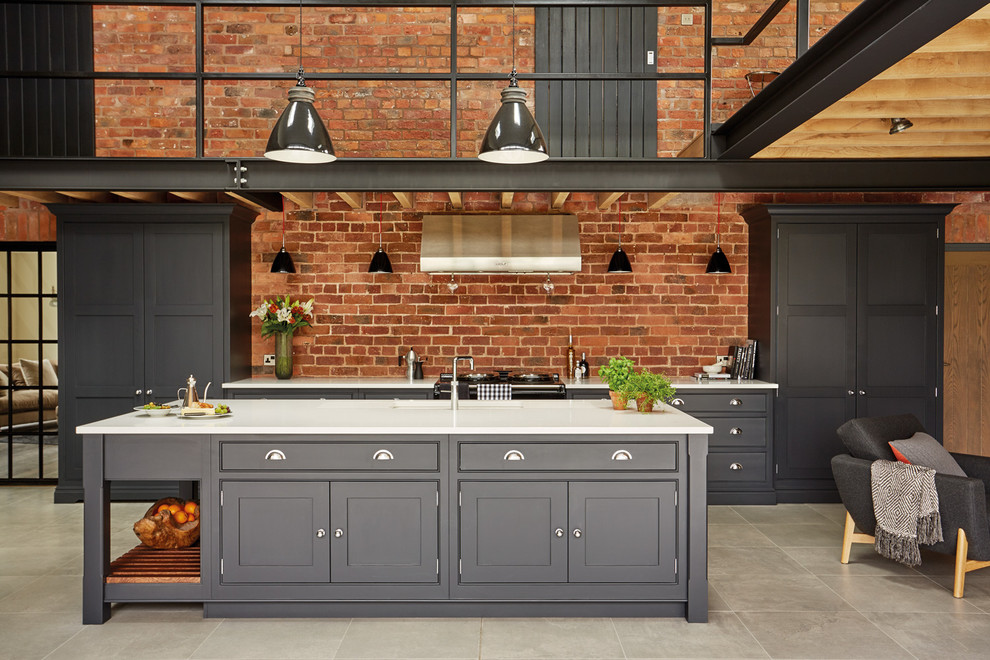 Photo of a large urban open plan kitchen in Manchester with shaker cabinets, black cabinets, quartz worktops, an island and integrated appliances.