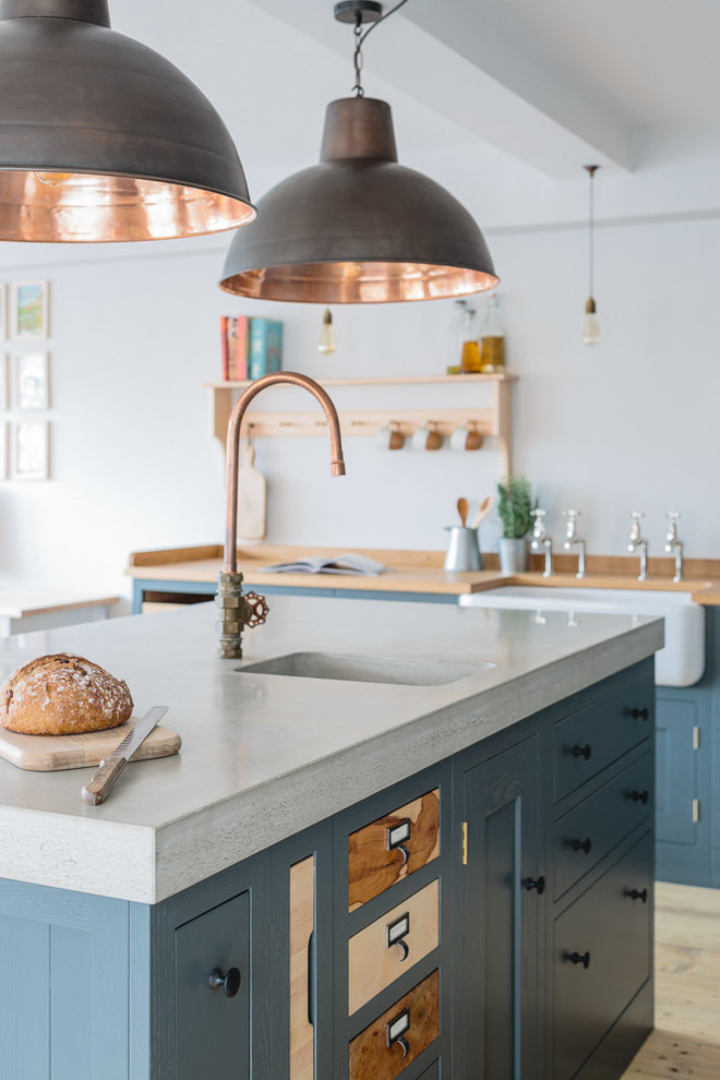 Immagine di una cucina industriale di medie dimensioni con lavello stile country, ante in stile shaker, ante grigie, top in cemento e parquet chiaro