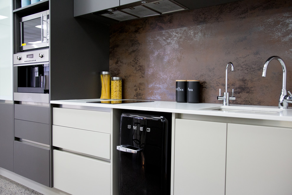 Inredning av ett industriellt mellanstort kök, med en undermonterad diskho, släta luckor, bruna skåp, rostfria vitvaror och en köksö