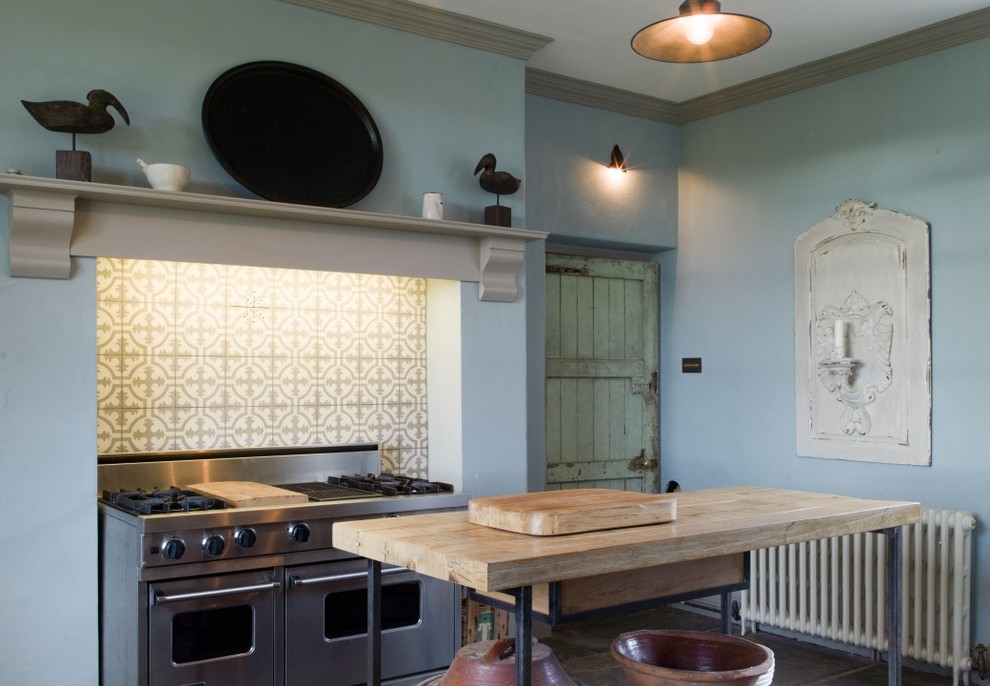 Bild på ett stort rustikt kök, med en rustik diskho, träbänkskiva, en köksö, skåp i shakerstil, rostfria vitvaror, skiffergolv och skåp i slitet trä