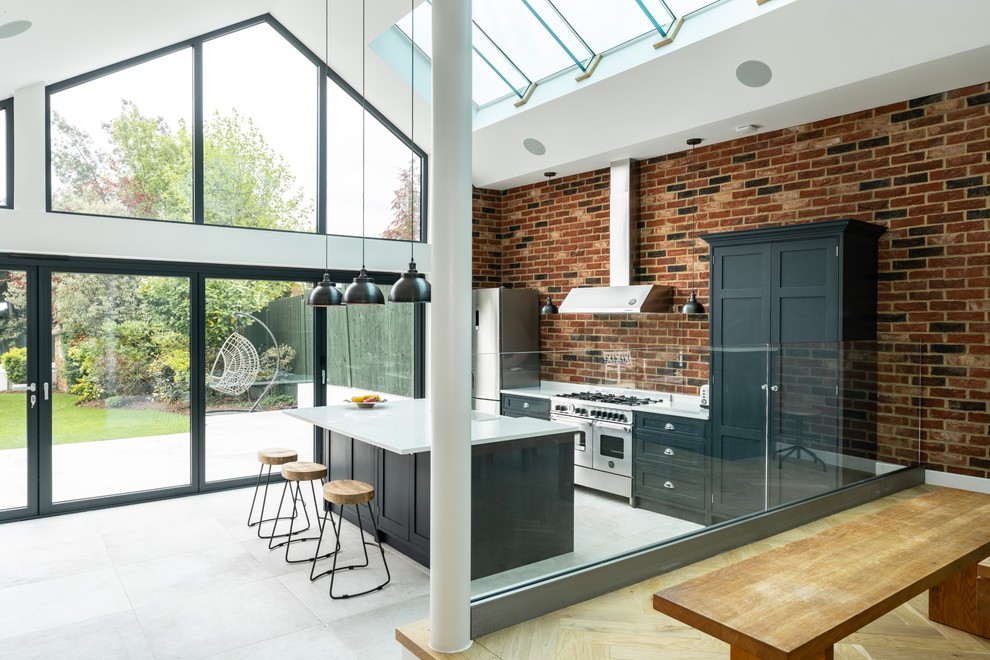 Ispirazione per una cucina classica di medie dimensioni con ante con riquadro incassato, ante blu, top in quarzite, paraspruzzi con lastra di vetro, elettrodomestici in acciaio inossidabile, pavimento in gres porcellanato e top bianco