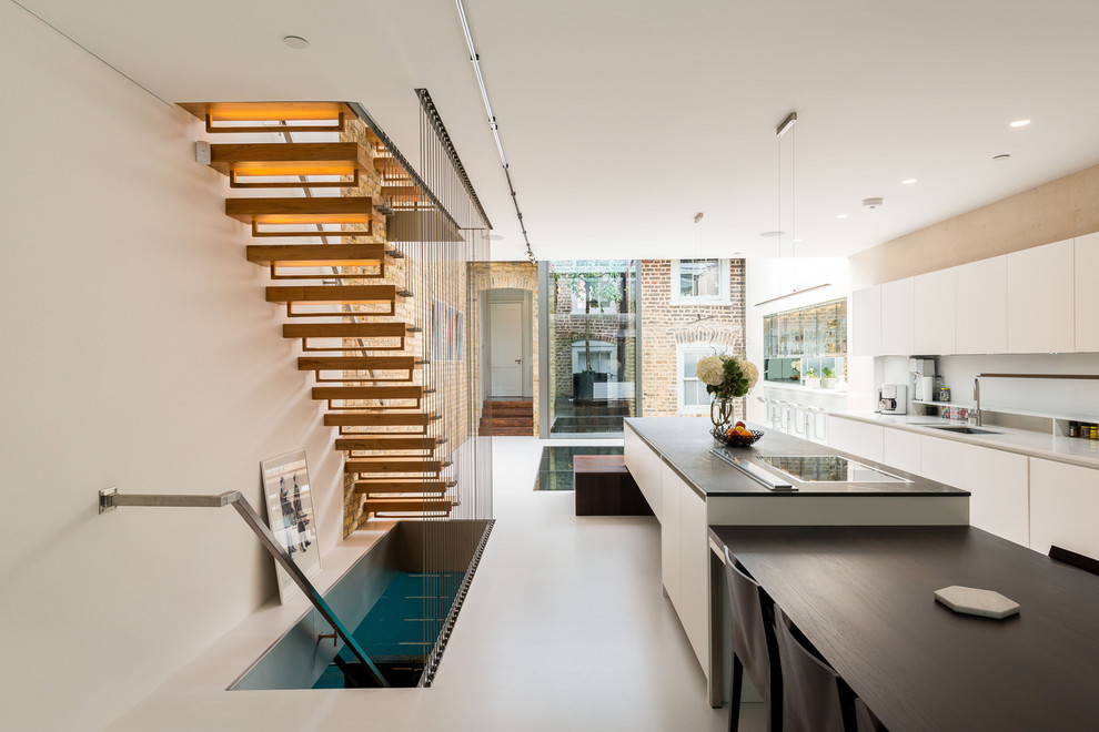 Einzeilige, Mittelgroße Moderne Wohnküche mit Doppelwaschbecken, flächenbündigen Schrankfronten, weißen Schränken, Linoleum, Kücheninsel und grauem Boden in London
