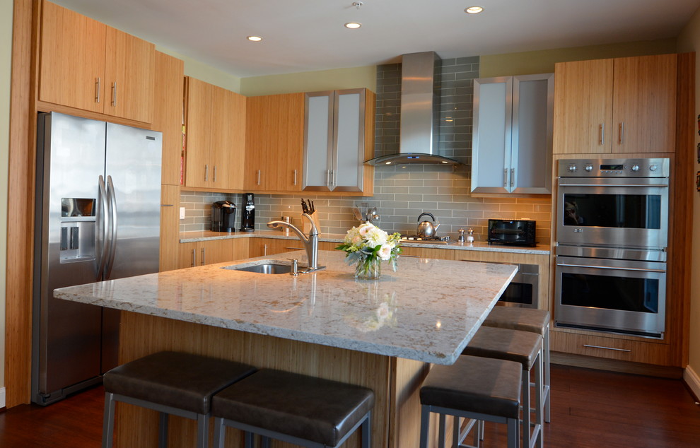 Modern inredning av ett mellanstort kök, med en undermonterad diskho, släta luckor, skåp i ljust trä, bänkskiva i kvarts, grått stänkskydd, stänkskydd i tunnelbanekakel, rostfria vitvaror, mellanmörkt trägolv och en köksö