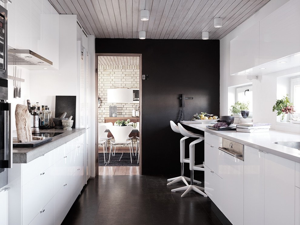 На фото: отдельная, параллельная кухня среднего размера в современном стиле с накладной мойкой, плоскими фасадами, белыми фасадами, гранитной столешницей и полом из керамической плитки без острова