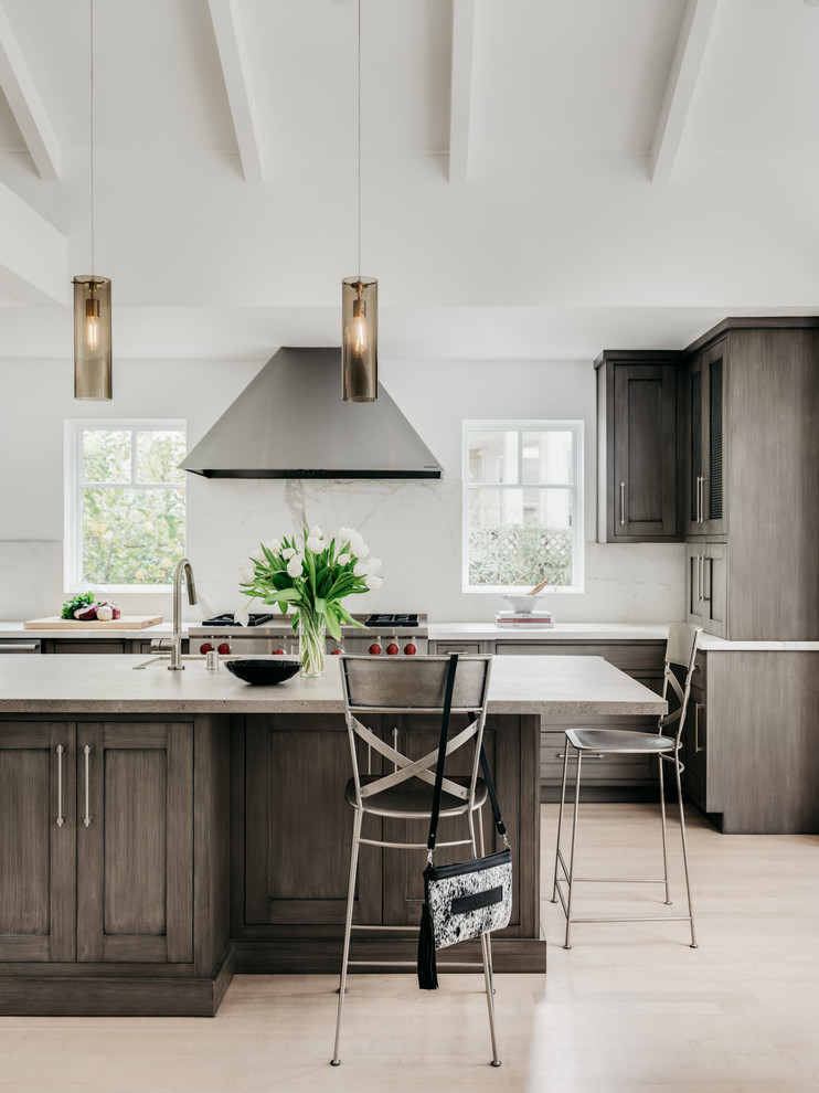 Example of a large transitional u-shaped light wood floor and beige floor eat-in kitchen design in San Francisco with an undermount sink, recessed-panel cabinets, medium tone wood cabinets, concrete countertops, white backsplash, stone slab backsplash, stainless steel appliances, an island and gray countertops