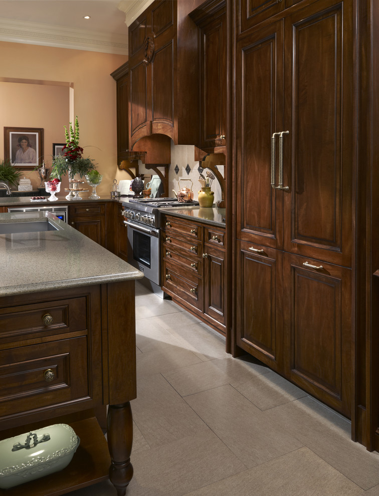 Inredning av ett klassiskt stort linjärt kök med öppen planlösning, med en undermonterad diskho, luckor med upphöjd panel, bänkskiva i kvarts, stänkskydd i stenkakel, integrerade vitvaror, skåp i mörkt trä, beige stänkskydd, klinkergolv i keramik, en köksö och vitt golv