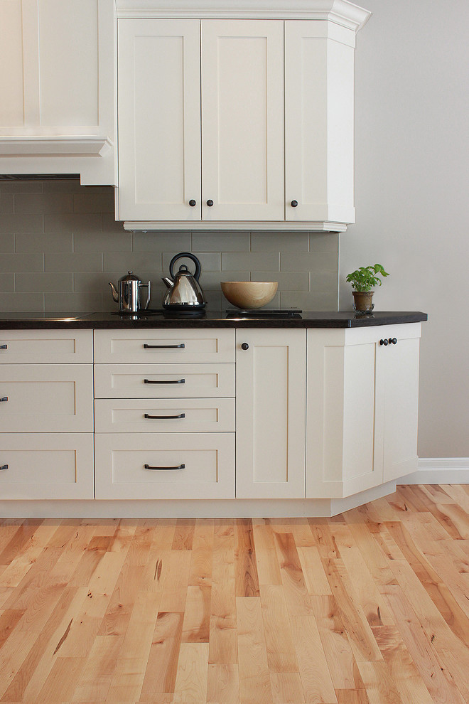 Einzeilige Skandinavische Küche mit Küchenrückwand in Grau, Küchengeräten aus Edelstahl, hellem Holzboden und Kücheninsel in Toronto