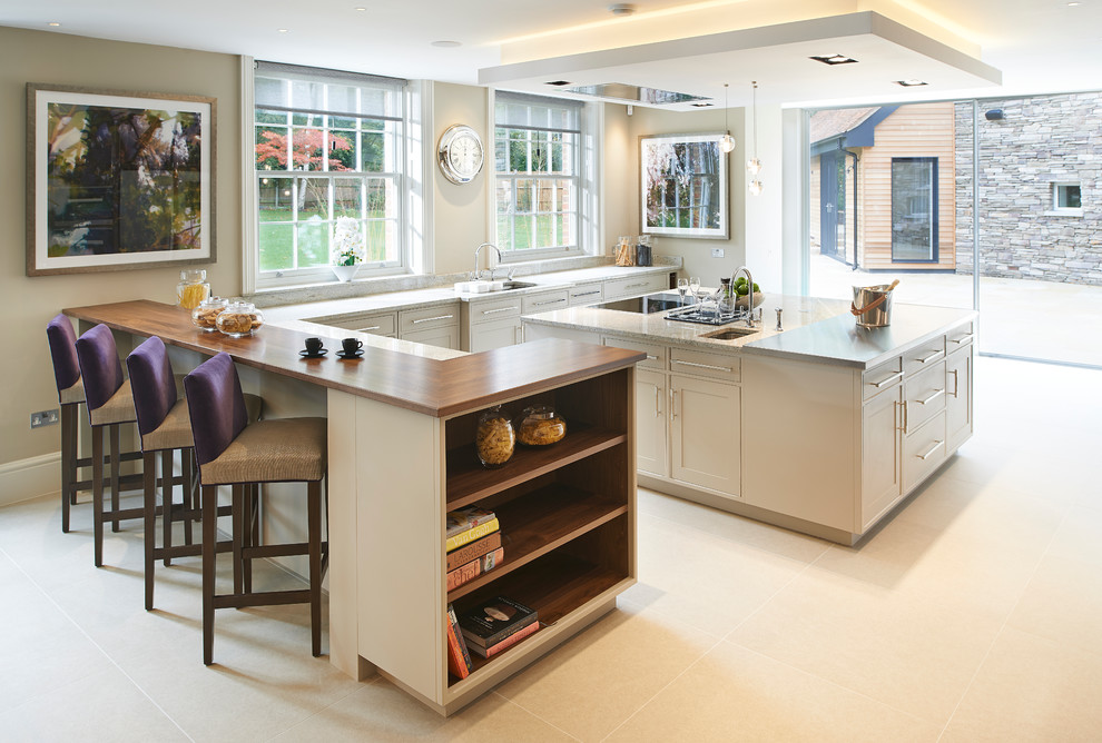Idée de décoration pour une cuisine américaine design en bois clair avec un plan de travail en granite et un sol en carrelage de céramique.