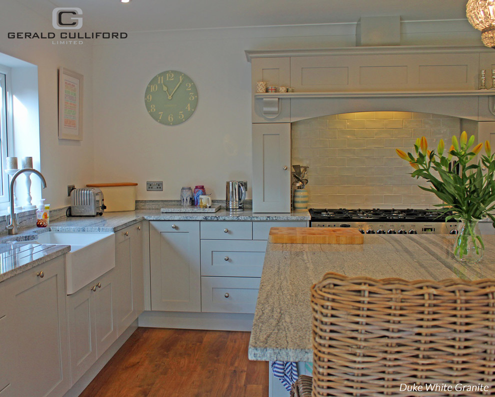 Mid-sized cottage l-shaped eat-in kitchen photo in London with granite countertops and an island