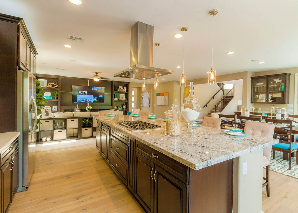 Inspiration for a huge contemporary single-wall light wood floor open concept kitchen remodel in Phoenix with a drop-in sink, raised-panel cabinets, dark wood cabinets, granite countertops, multicolored backsplash, ceramic backsplash, stainless steel appliances and an island