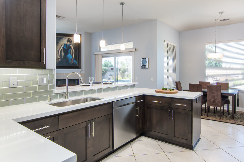 Mid-sized transitional u-shaped porcelain tile and beige floor eat-in kitchen photo in Los Angeles with an undermount sink, recessed-panel cabinets, dark wood cabinets, quartzite countertops, gray backsplash, glass tile backsplash, stainless steel appliances, a peninsula and white countertops