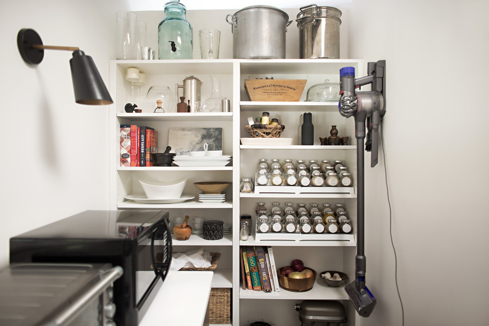 This is an example of a midcentury kitchen pantry in Cincinnati with open cabinets, white cabinets and white benchtop.