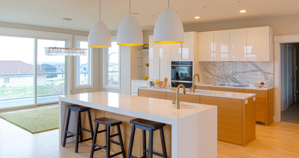 This is an example of an expansive modern kitchen/diner in Other with a single-bowl sink, white cabinets, engineered stone countertops, white splashback, marble splashback, black appliances, light hardwood flooring and multiple islands.