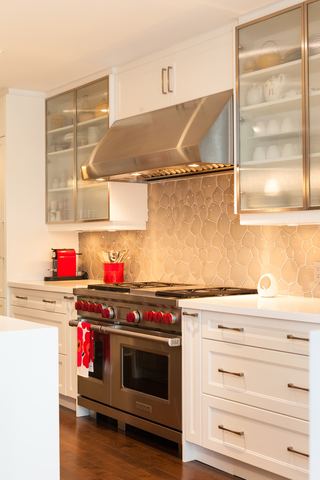 Zweizeilige Klassische Küche mit Schrankfronten im Shaker-Stil, weißen Schränken, Küchenrückwand in Beige, Rückwand aus Glasfliesen, Küchengeräten aus Edelstahl, braunem Holzboden und Kücheninsel in Toronto