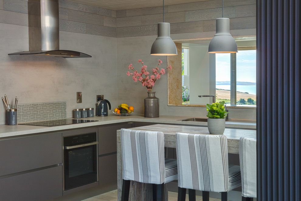 Inspiration för mellanstora nordiska kök, med en undermonterad diskho, släta luckor, grå skåp, marmorbänkskiva, grått stänkskydd, rostfria vitvaror och en halv köksö